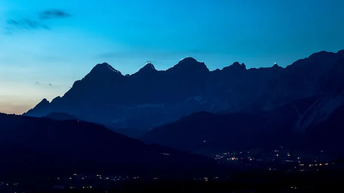 Die Gratbeleuchtung des Dachstein-Dreigestirns Torstein, Mitterspitz und Hoher Dachstein begann mit weißen Lichtern (Stirnlampen der Bergretter).