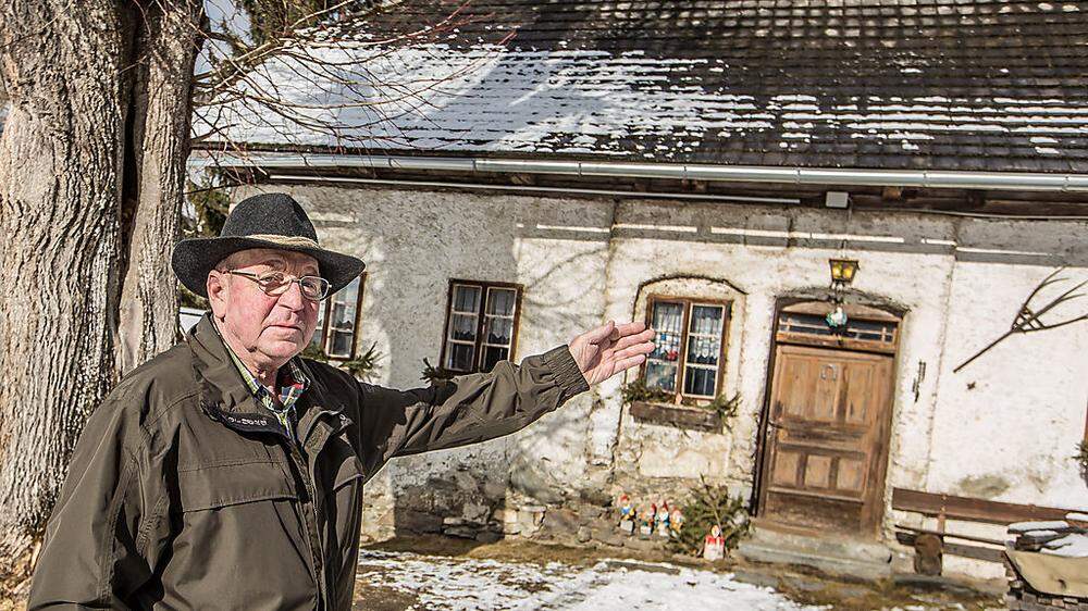 Helmut Ebner vor dem alten Haus der Familie in Treffen, auf dem eine Steintafel den Vulgonamen "Pruger" zeigt
