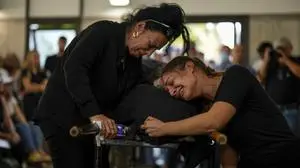 Mourners react beside the body of Mapal Adam, during her funeral in Tel Aviv, Israel, Wednesday, Oct. 11, 2023. Adam was killed by Hamas militants on Saturday as they carried out an unprecedented, multi-front attack that killed over 1,000 Israelis. (AP Photo/Francisco Seco)