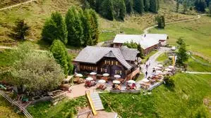 Eine Luftaufnahme einer Almhütte | Die Lammersdorfer Hütte liegt eingebettet in die Formationen der Nockberge auf 1650 Meter hoch über dem Millstätter See