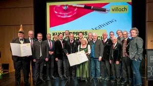 Zahlreiche Menschen stehen auf der Bühne, manche halten Urkunden in den Händen | Anfang November wurde der Kulturpreis der Stadt Villach an den Villacher Kirchtag und den Villacher Fasching vergeben