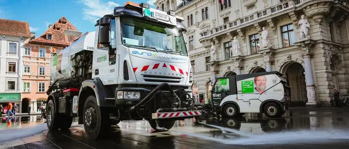 Zwei Tanklastwagen am Grazer Hauptplatz, die gerade den Platz mit Wasser sauber spritzen