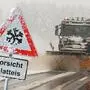 Ein Winterdienst-Fahrzeug vor einem Schild „Vorsicht Glatteis“ | Auf Kärntens Straßen wird es eisig (Symbolfoto)