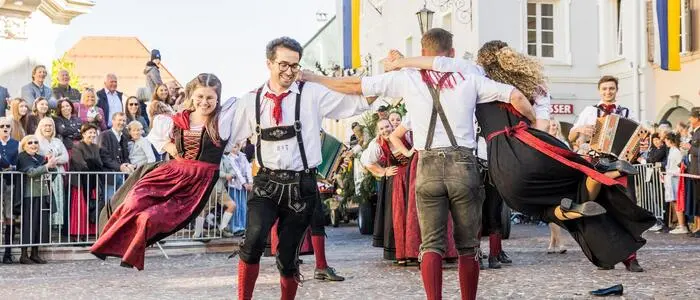 Junge, tanzende Menschen in Tracht in der St. Veiter Altstadt.