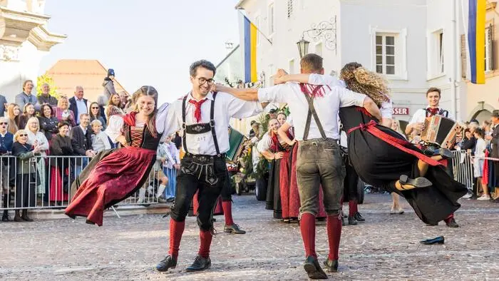 Junge, tanzende Menschen in Tracht in der St. Veiter Altstadt.