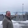 Freddy Wascher am Parkplatz vor seinem Hotel, im Hintergrund ist der Masten zu sehen