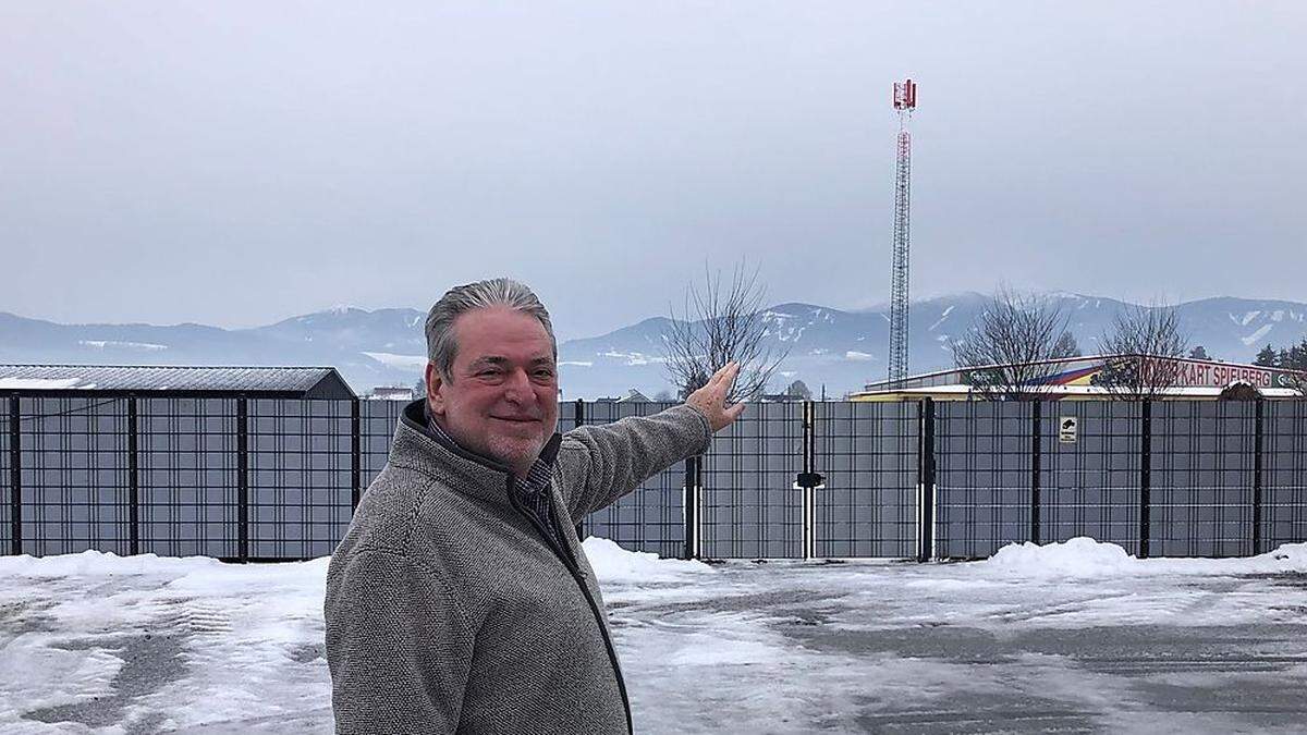 Freddy Wascher am Parkplatz vor seinem Hotel, im Hintergrund ist der Masten zu sehen