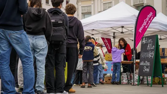 Eine Schlange von Menschen steht vor einem Pavillon