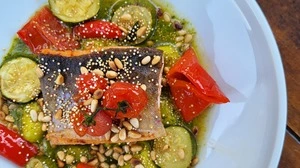 Gebratenes Saiblingsfilet mit Kräuter-Pesto-Gnocchi, Paprika, Zucchini und Pinienkernen.