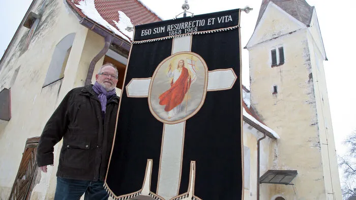 Obmann Herbert Müller mit der 100er-Jubiläumsfahne mit der Aufschrift „Ich bin die Auferstehung und das Leben“