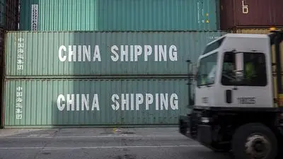 FILE- In this July, 5, 2018, file photo, a jockey truck passes a stack of 40-foot China Shipping containers at the Port of Savannah in Savannah, Ga.  The path to peace in a trade war between the United States and China is getting harder to find as the world's two biggest economies pile ever more taxes on each other's products. (AP Photo/Stephen B. Morton, File)