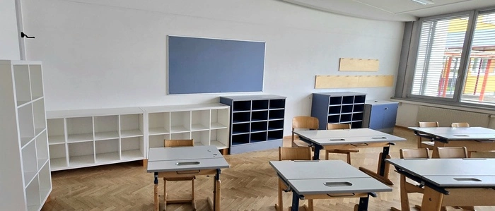 Ein Blick in einen Klassenraum mit Tischen und Schulbänken 