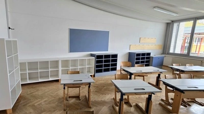 Ein Blick in einen Klassenraum mit Tischen und Schulbänken 