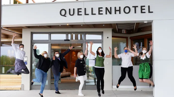 Freudensprung des Teams vor dem Quellenhotel und der Heiltherme.