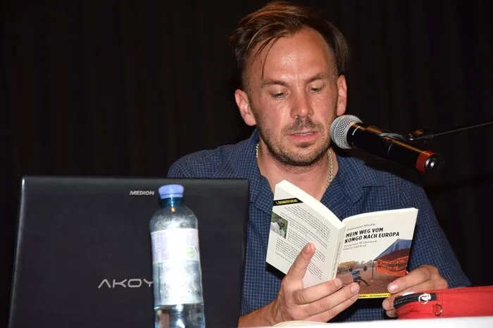 Von einem dramatischen Flüchtlingsschicksal berichtete der Journalist Alexander Behr, der aus dem Buch „Mein Weg vom Kongo nach Europa“ von Emmanuel Mbolela über dessen Flucht aus dem Kongo berichtete. Mbolela hatte dort gegen Menschenrechtsverletzungen durch die Regierung gekämpft, wurde verfolgt, was ihn zur Flucht zwang; er lebt heute im Exil in Belgien. „Der Kongo wird heute systematisch ausgebeutet“, so Behr.