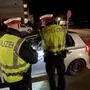 Zwei Polizisten halten einen Autofahrer an. | In der Weihnachtszeit wurden 48 Führerscheine abgenommen (Symbolfoto)