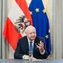 Bundeskanzler Christian Stocker vor einer Österreich- und einer EU-Flagge