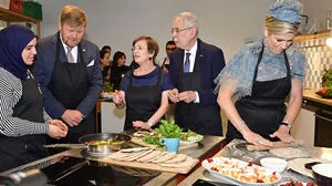 Das Königspaar mit Österreichs Präsidentenpaar beim Backen in einer Caritas-Küche