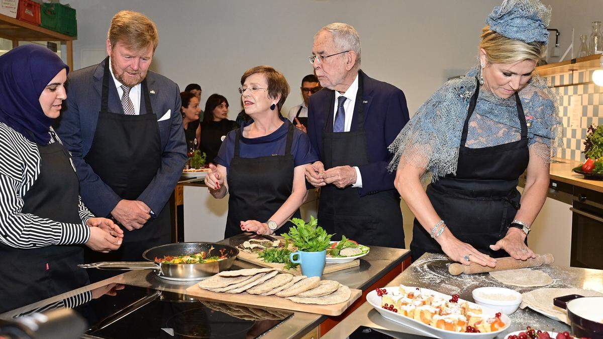 Das Königspaar mit Österreichs Präsidentenpaar beim Backen in einer Caritas-Küche