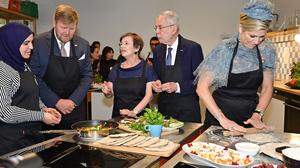 Das Königspaar mit Österreichs Präsidentenpaar beim Backen in einer Caritas-Küche