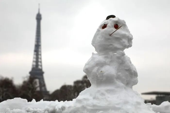 Ein Schneemann nahe des Pariser Eiffelturms