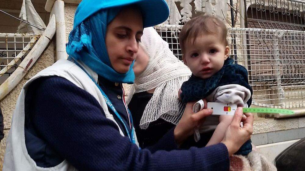 Eine Unicef-Mitarbeiterin in Madaya mit einem unterernährten Kind, Archivbild