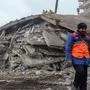 A man walks past a collapsed building as rescuers search for victims and survivors in the rubble, a day after a 7.8-magnitude earthquake struck the country's southeast, in Diyarbakir on February 7, 2023. - A massive rescue effort in Turkey and Syria battled frigid weather in a race against time to find survivors after the quake struck on February 6, 2023, flattening thousands of structures, trapping an unknown number of people and potentially impacting millions. (Photo by ILYAS AKENGIN / AFP)