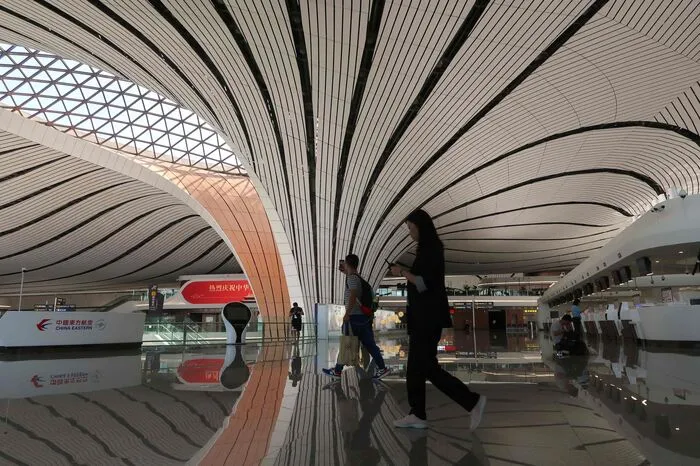 Der Flughafen wurde von der 2016 gestorbenen irakischen Architektin Zaha Hadid und ihren chinesischen Partnern entworfen, hat organische Formen und viel natürliches Licht.