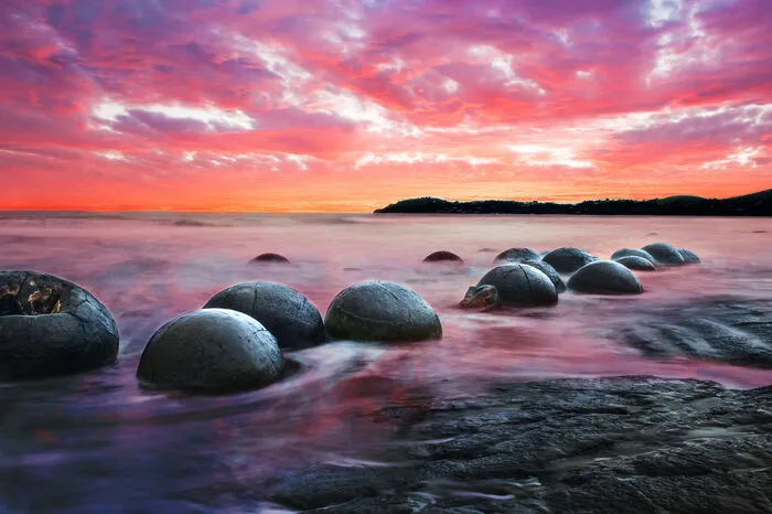 Die Moeraki Boulders zeigen sich bei Ebbe und bieten ein spektakuläres Fotomotiv an diesem Sandstrand an der Küste Otago auf der Südinsel Neuseelands.