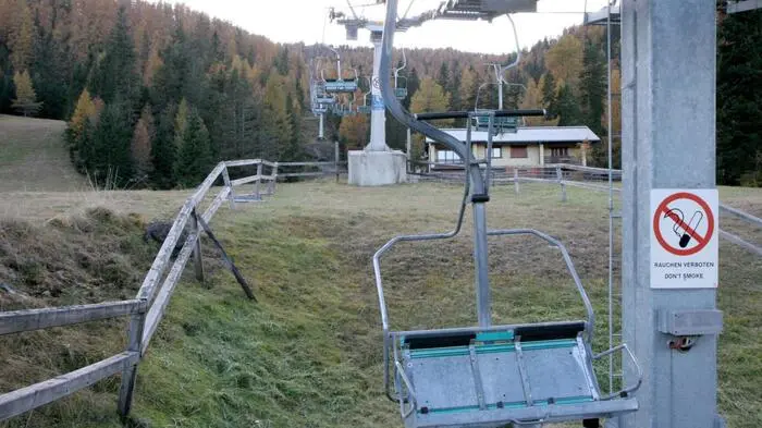 Ein leerer Sessellift in einem Skigebiet. Es liegt kein Schnee, das Foto wurde voraussichtlich Anfang Herbst aufgenommen.