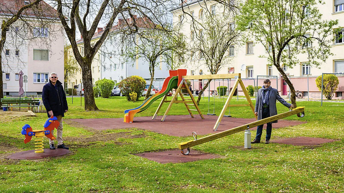 Vizebürgermeister Alois Dolinar und Reinfried Oblasser, Geschäftsführer von Klagenfurt Wohnen, besichtigen die neuen Spielgeräte.
