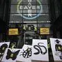 (FILES) In this file photo taken on March 14, 2019, activists stage a flash protest organised by the international movement Attac at the offices of Bayer - which recently acquired Monsanto - in La Garenne Colombes near the financial district of La Defense on the outskirts of Paris. - Germany's Bayer apologised on May 12, 2019 after revelations in France that its subsidiary Monsanto had a PR agency collate lists of politicians, scientists and journalists and their views on pesticides and GM crops. (Photo by Philippe LOPEZ / AFP)