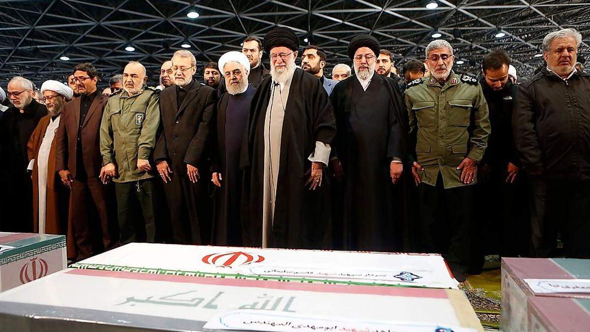 Der iranische Führer Ayatollah Ali Khamenei (Mitte), Präsident Hassan Rouhani (erster links von ihm) und Parlamentssprecher  Ali Larijani (zweiter links von ihm) am Sarg von General Qassem Soleimani.