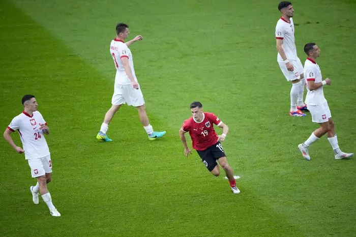 Austria's Christoph Baumgartner, center, celebrates after scoring his side's second goal during a Group D match between Poland and Austria at the Euro 2024 soccer tournament in Berlin, Germany, Friday, June 21, 2024. (AP Photo/Petr Josek)