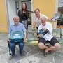 Bibliotheksleiter Wolfgang Pojer, Organisatorin Anna Hutter, Bibliotheksmitarbeiterin Ulla Patz und Heimo Putz, Moderator der Versteigerung, mit Gegenständen, die versteigert werden