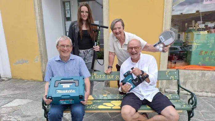 Bibliotheksleiter Wolfgang Pojer, Organisatorin Anna Hutter, Bibliotheksmitarbeiterin Ulla Patz und Heimo Putz, Moderator der Versteigerung, mit Gegenständen, die versteigert werden