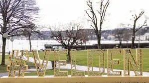 Blick auf einen See, im Vordergrund steht Velden in großen goldenen Lettern