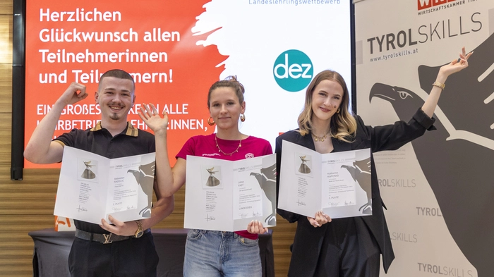 Die drei Bestplatzierten jubeln in Innsbruck und zeigen ihre Urkunden