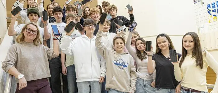 Schüler und Lehrerin mit Handys | Noch haben die Viertklässler des BORG Wolfsberg ihre Handys. Auch Lehrerin Eva Fischer wird ihr Smartphone am Mittwoch abgeben