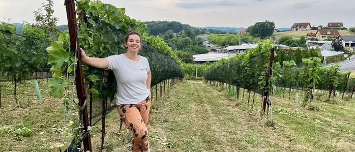 Julia Zotter im Weingarten mit Blick auf das Zotter-Imperium