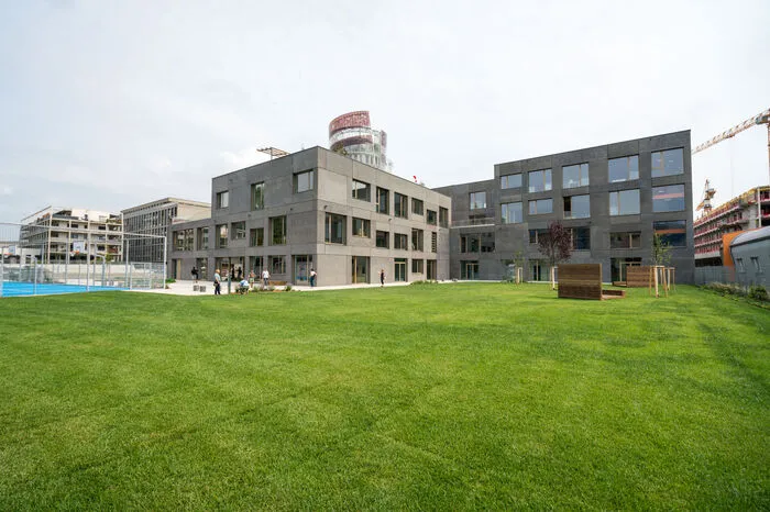 Ein Blick auf das gesamte vierstöckige Gebäude vom Sportplatz aus. 