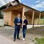 Ein Mann und eine Frau stehen vor einer neuen barrierefreien Sanitäranlage