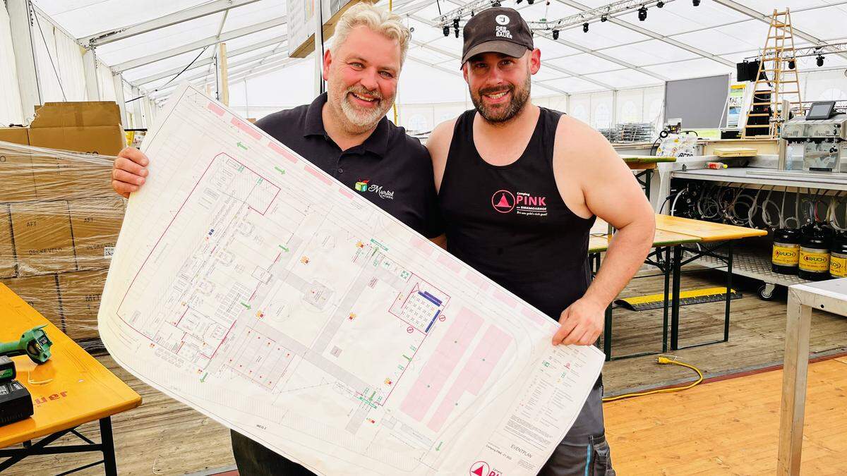 Peter Dietrich und Harald Saiger mit dem Übersichtsplan ihres Gastro-Areals am Campinggelände des Red Bull Ring