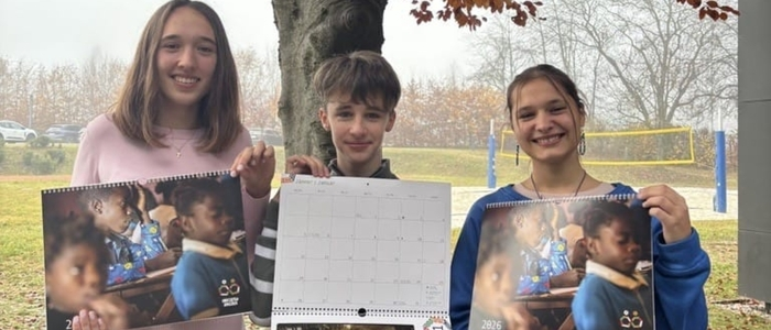 Drei Schüler stehen vor einem herbstlichen Baum und halten jeweils einen Wandkalender | Viktoria Škof, Alexander Hobel, Neva Kert (von links)