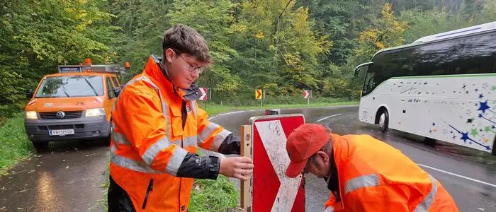 Straßenerhaltungsdienst-Lehrling Julian Josef Grein (l.) und Leonhard Neuherz bauen die umgefahrene Richtungstafel in der Kehre am Taxberg (B 66) wieder ein