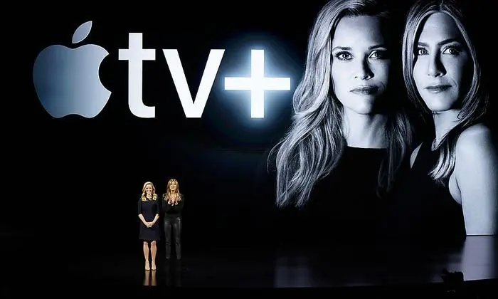 Actors Reese Witherspoon, left, and Jennifer Aniston speak at the Steve Jobs Theater during an event to announce new Apple products Monday, March 25, 2019, in Cupertino, Calif. (AP Photo/Tony Avelar)