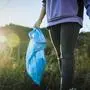  Volunteer walking in grass holding garbage bag on sunset model released, Symbolfoto, ACPF01530