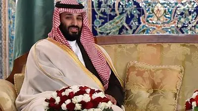 Saudi Crown Prince Mohammed bin Salman (L) meets Algerian Prime Minister Ahmed Ouyahia (R) upon the former's arrival at Algiers on December 2, 2018. (Photo by RYAD KRAMDI / AFP)