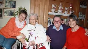 Juliana Rauter an ihrem 102. Geburtstag im Jahr 2024 mit ihren Kindern Christine, Alfred und Juliane. Die Jubilarin sitzt im Rollstuhl und hält Blumen in den Händen