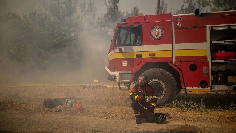 Ein Feuerwehrmann aus der Slowakei kühlt sich kurz bei seinem Einsatz in Griechenland ab